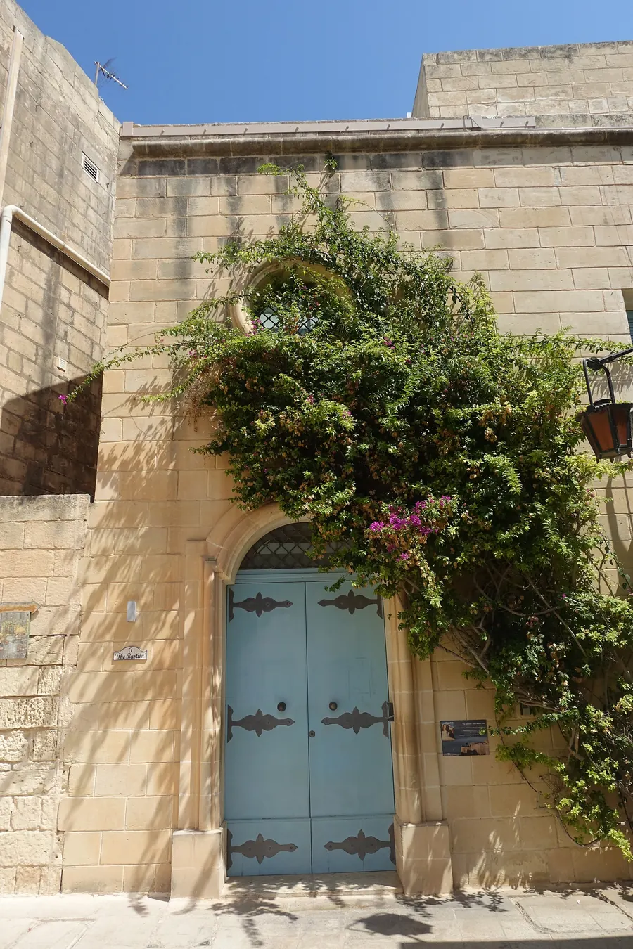 A limestone doorway draped in bougainvillea in Mdina, Malta